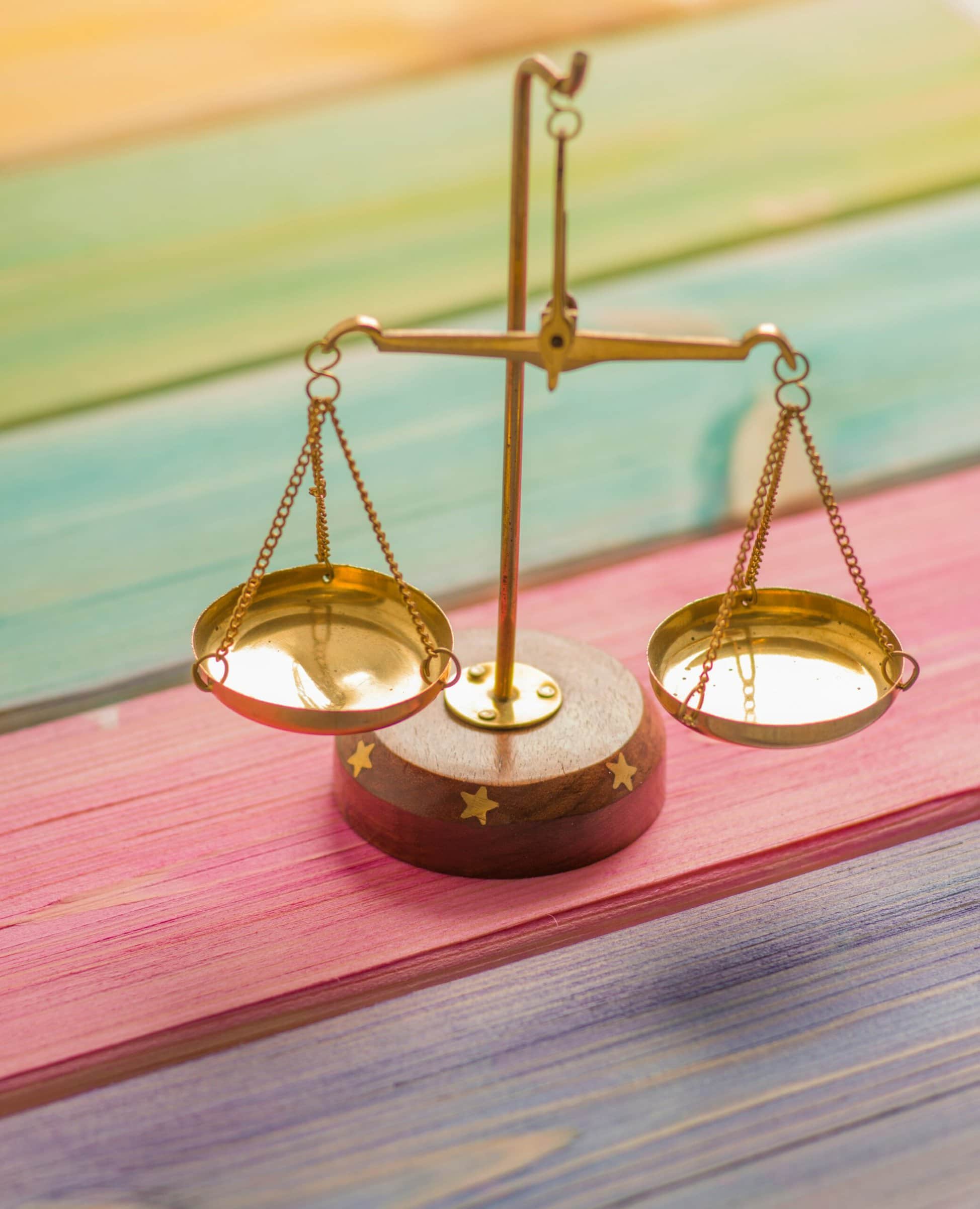 A gold apothecary scale on a colorful table